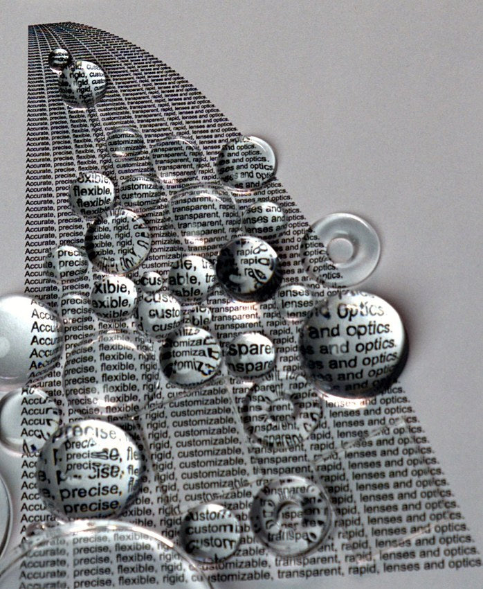 Silicone lens beads magnifying printed text, demonstrating optical clarity